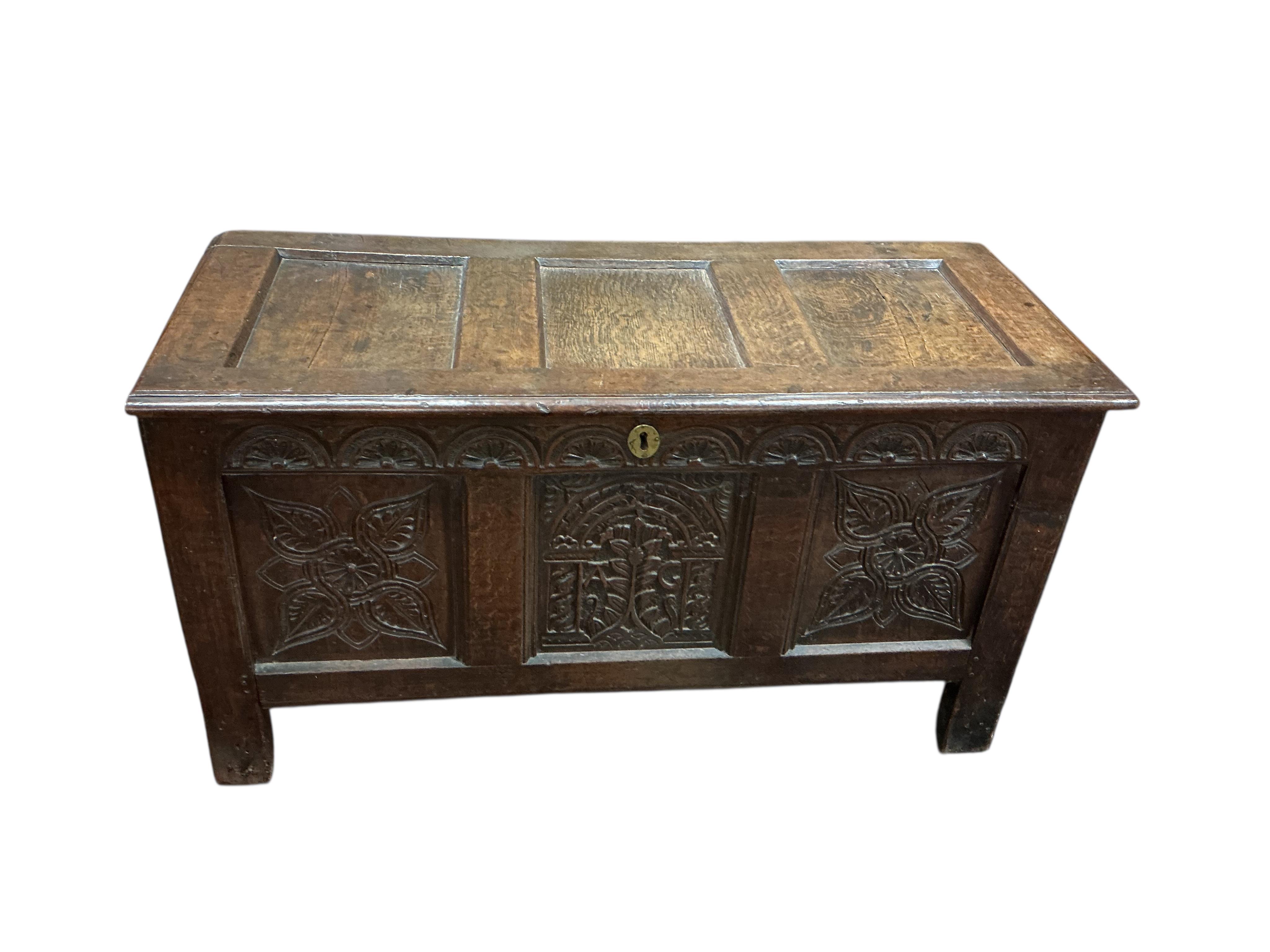 An 18th century carved oak coffer, width 124cm, depth 54cm, height 67cm